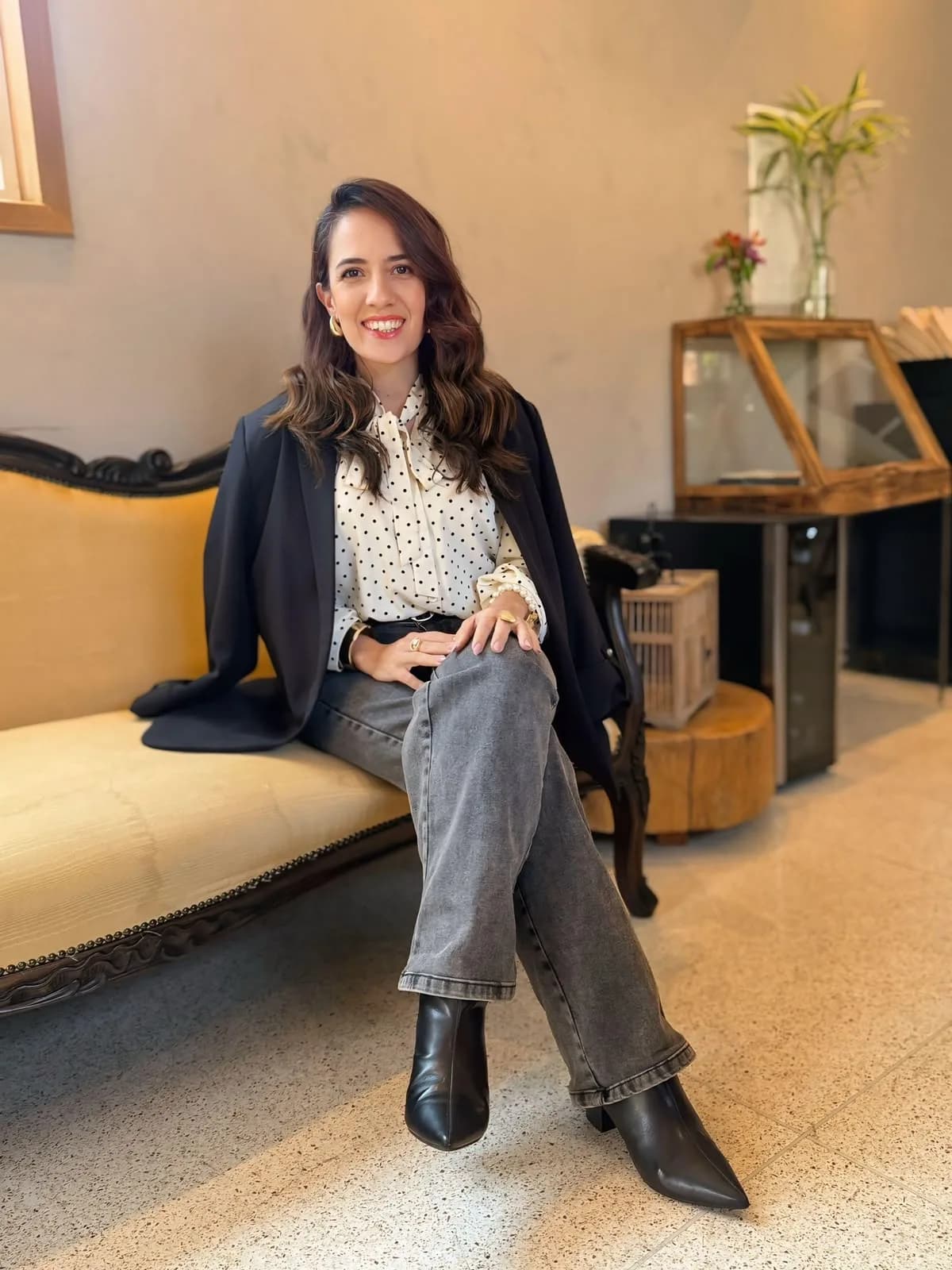 Vanessa Bento sentada, de blazer preto e camisa clara